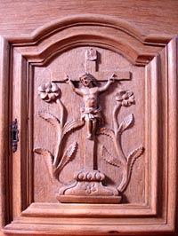 Christ en bois sculpté sur une porte de l'armoire de l'abside.