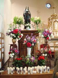 Statue de sainte Gode abondamment fleurie à l’occasion d’un pèlerinage.