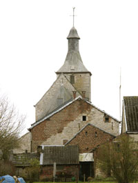 L’église de Tohogne avec, à l’avant-plan, le large pignon « est » de la cure avec ses traces bien apparentes de transformations. Tout en avant : vestiges d’anciennes annexes.