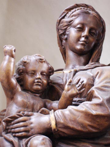 Cette Vierge debout à l’enfant située côté Evangile de l’autel est une pure merveille. De style baroque, elle est attribuée à Renier Panhay de Rendeux, ce célèbre sculpteur liégeois ayant vécu sa jeunesse dans la région rochoise. Certes cette époque du geste, du mouvement tire à sa fin. Ici l’emphase est mesurée. Le visage de la vierge est splendide et tend à la perfection; son sourire empreint de fierté lui confère une beauté céleste. L’Enfant-Jésus est à son image; plus expressif, il apparaît enjoué et donne l’impression de babiller.