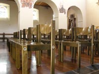 Chaises modernes en hêtre placées dans la grande nef.