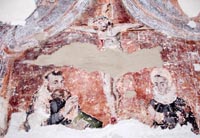 Détail de la peinture murale : les donateurs en prière ; à l’arrière-plan : un Christ en croix massif. 